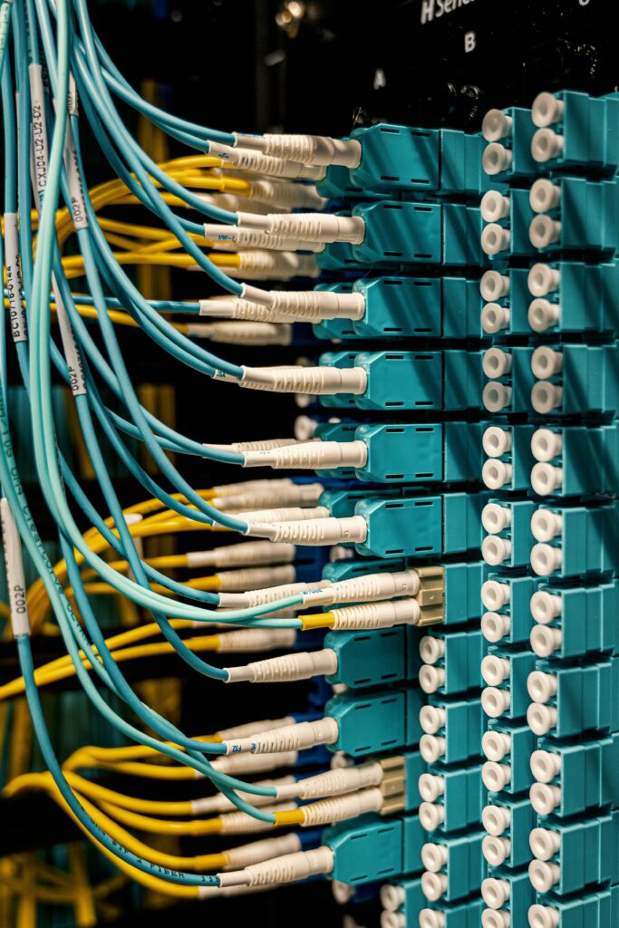 pexels-photo-4497197-4497197 Blue and yellow optical fiber cables connected to ports in a server room.